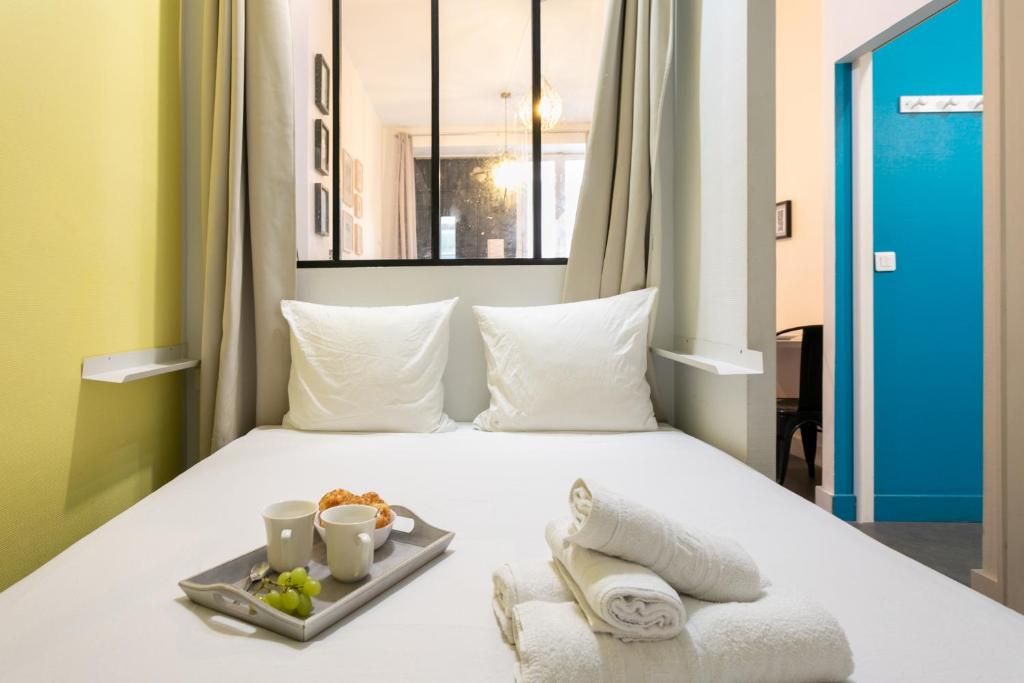 - une chambre d'hôtel avec un lit et un plateau de nourriture dans l'établissement WS Opéra-Folies Bergères, à Paris