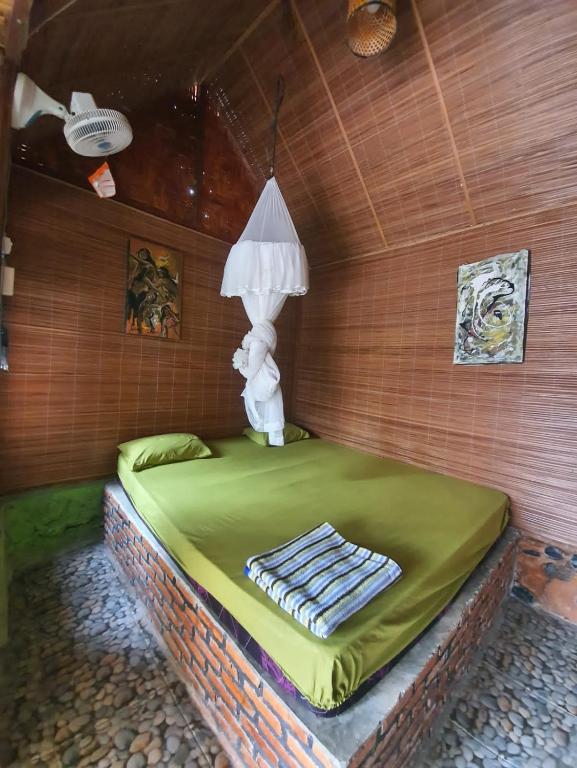 una camera con un letto con una lampada sopra di Lucky Bamboo'Bungalows-Resto and Orangutan Jungle Trekking Tours a Bukit Lawang