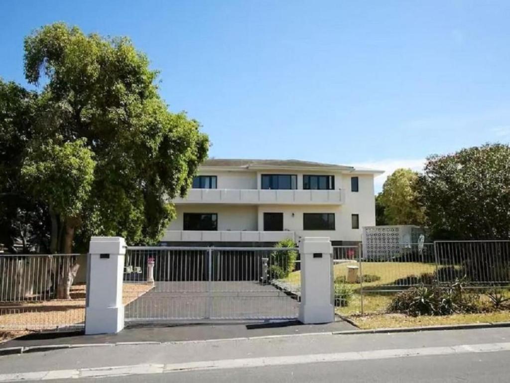 a white building with a fence in front of it at Cape Dawn Guest House in Parow