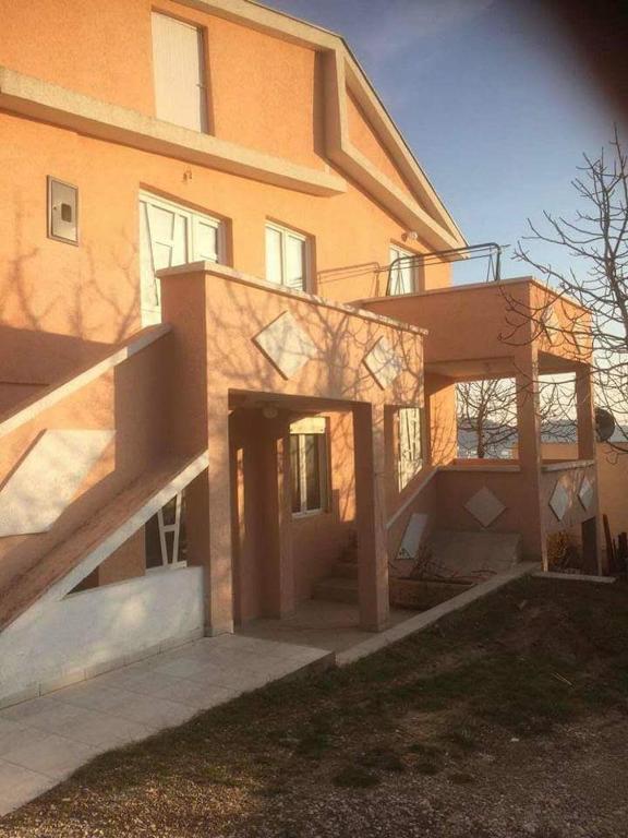 a house with a staircase in front of it at Apartmani Dević Šušanj in Bar