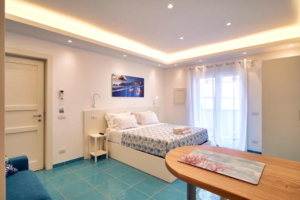 um pequeno quarto com uma cama e uma mesa em ilTrucioloBBSuite em Anacapri