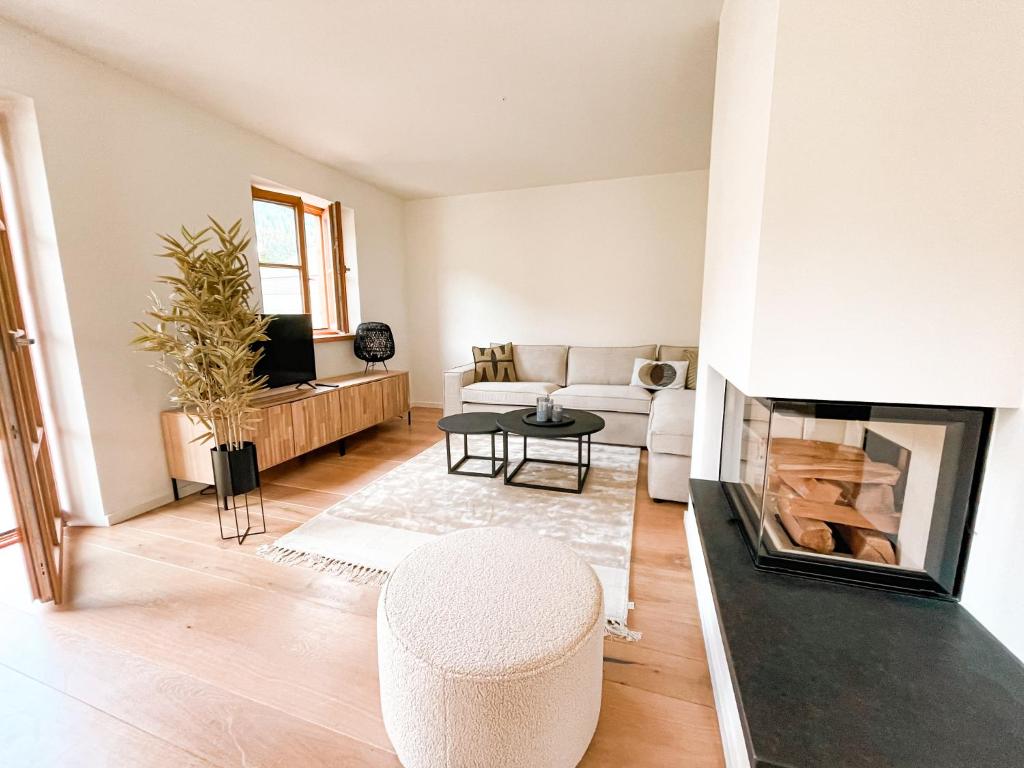 a living room with a couch and a fireplace at Lichtdurchflutete Doppelhaushälfte in Kreuth in Kreuth