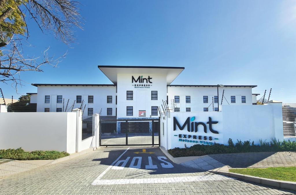un edificio blanco con un cartel en la parte delantera en MINT Express Melrose View en Johannesburgo