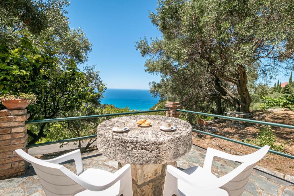 a patio with a table and chairs and the ocean at Elies Villa Corfu in Áno Garoúna