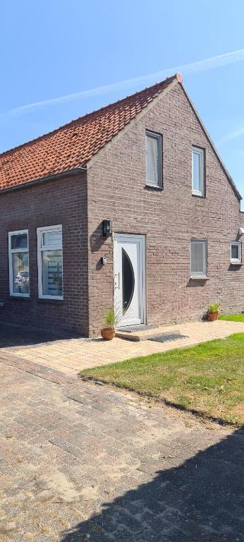 een stenen huis met een deur met een raam bij Maisonnette Slijkplaat 18 in Hoofdplaat