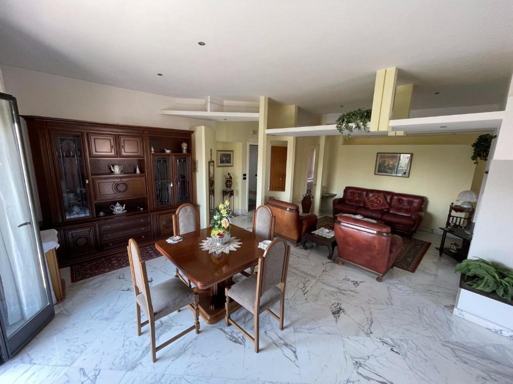 ein Wohnzimmer mit einem Holztisch und Stühlen in der Unterkunft Geltrude in Avola