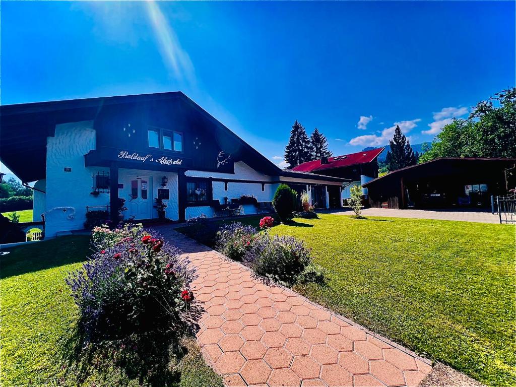 a house with a brick path in front of a building at Baldauf's Alpchalet in Oberstdorf