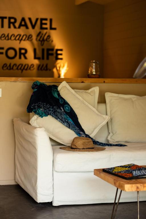a white couch with pillows and a sign on the wall at Mwezi Boutique Resort in Jambiani