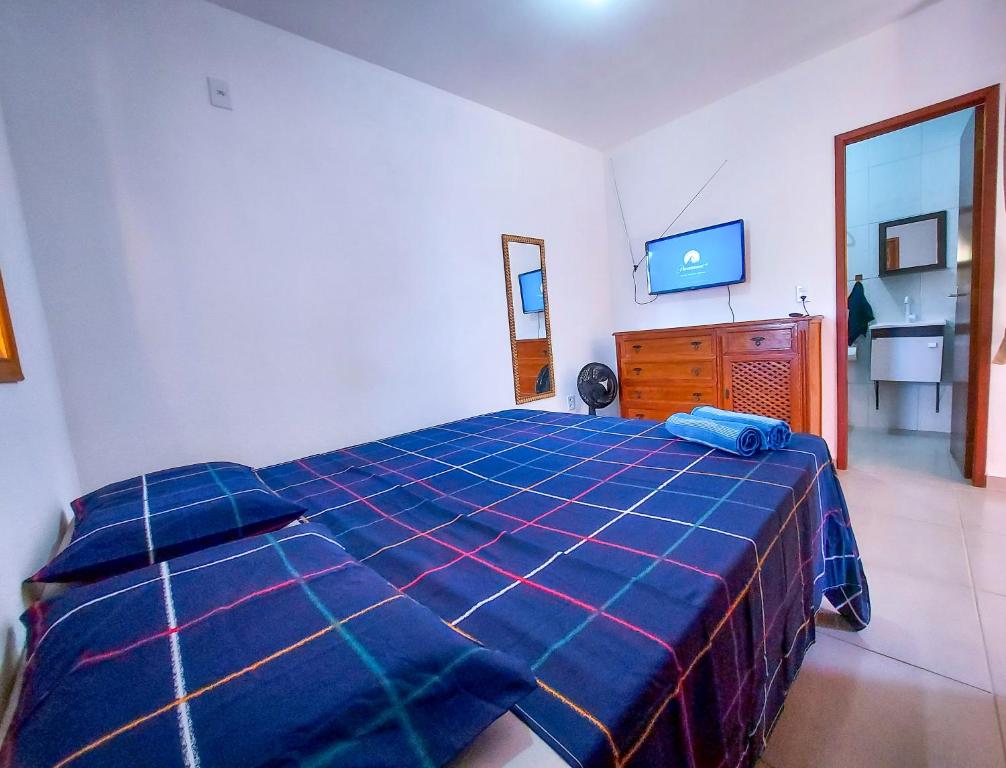 1 dormitorio con 1 cama, vestidor y TV en Aconchego na Chapada, en Lençóis