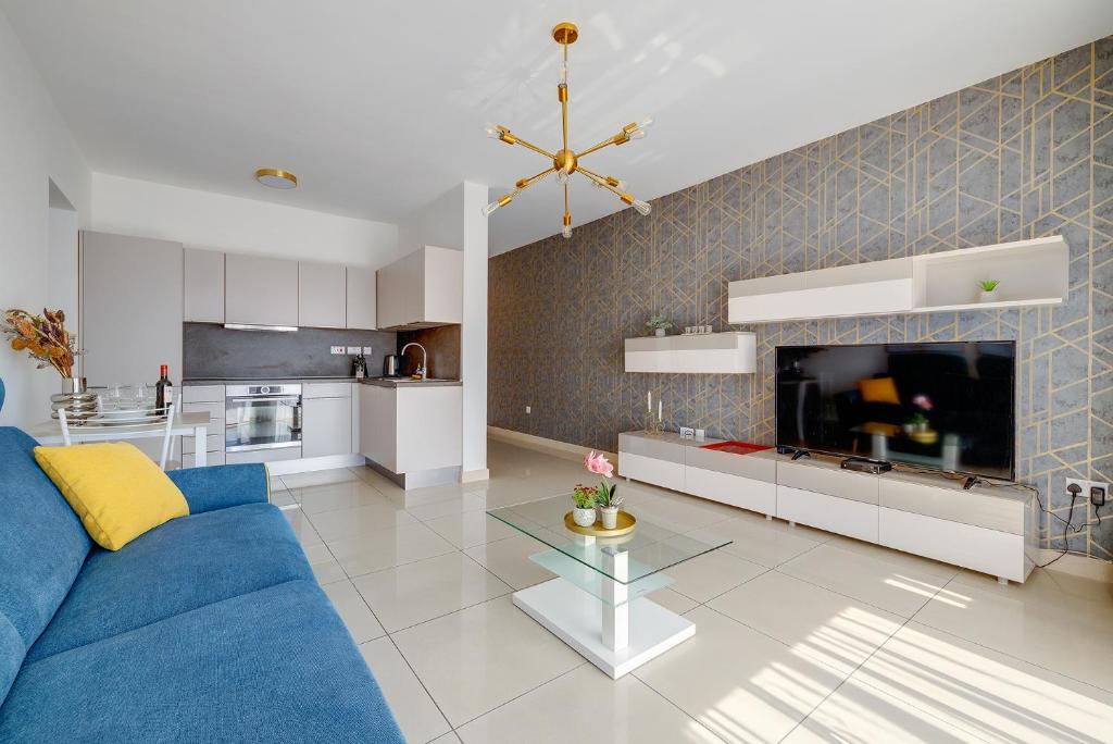 ein Wohnzimmer mit einem blauen Sofa und einer Küche in der Unterkunft Luxury Apartment with Balcony, Central Area in Gżira