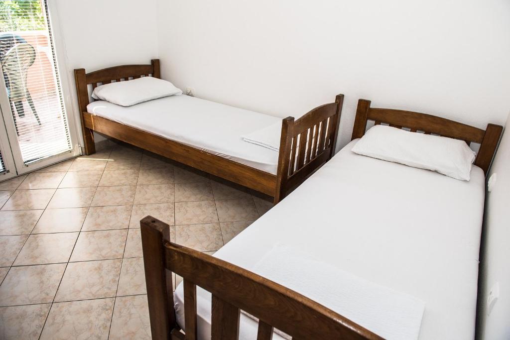 dwa łóżka pojedyncze w pokoju z oknem w obiekcie Apartment Lucky 1 w mieście Tivat