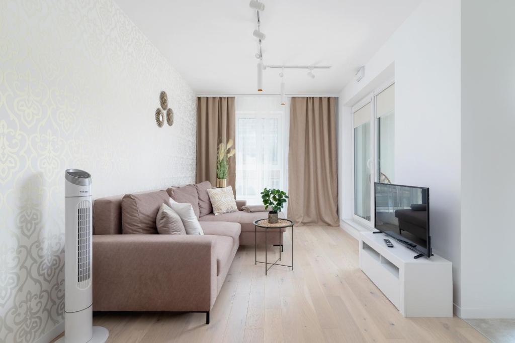 a living room with a couch and a tv at Apartment with Balcony & Parking Mogilska by Renters Prestige in Krakow