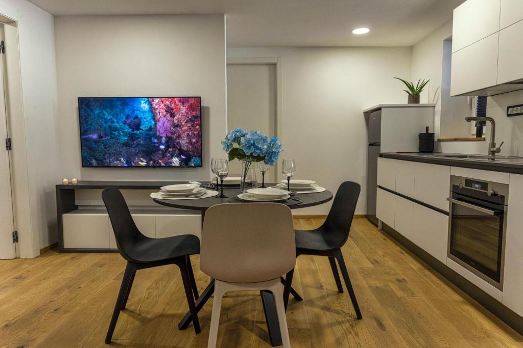 uma sala de jantar com uma mesa e cadeiras numa cozinha em Poseidon Apartment em Izola