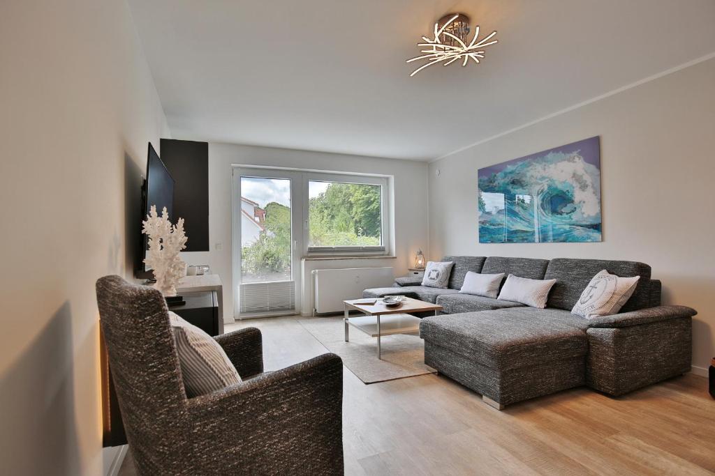 a living room with a couch and two chairs at Haus am Seehof Ferienwohnung Ostseeliebe in Sierksdorf