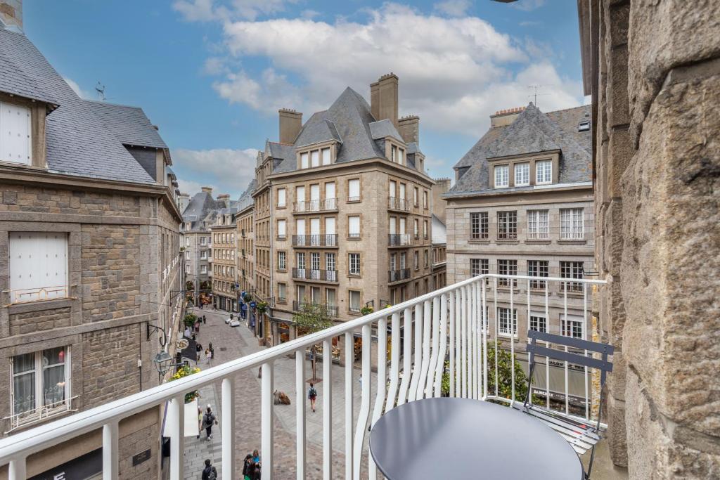 a balcony with a table and some buildings at L'ILE AUX MOUETTES - en plein Intra-Muros in Saint Malo