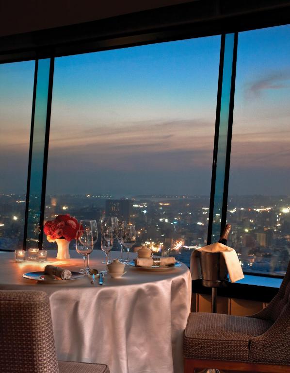 a table with wine glasses and a view of the city at Shangri-La Far Eastern Tainan in Tainan