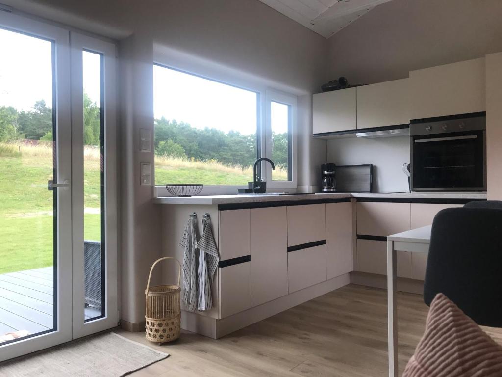 eine Küche mit weißen Schränken und einem großen Fenster in der Unterkunft TINY LIEBE Ostsee Ostsee- bei Wismar in Neuburg