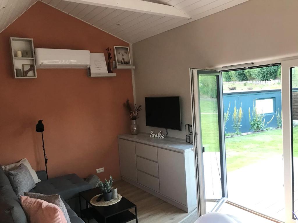 a living room with a couch and a tv at TINY LIEBE Ostsee Neu Farpen in Neuburg