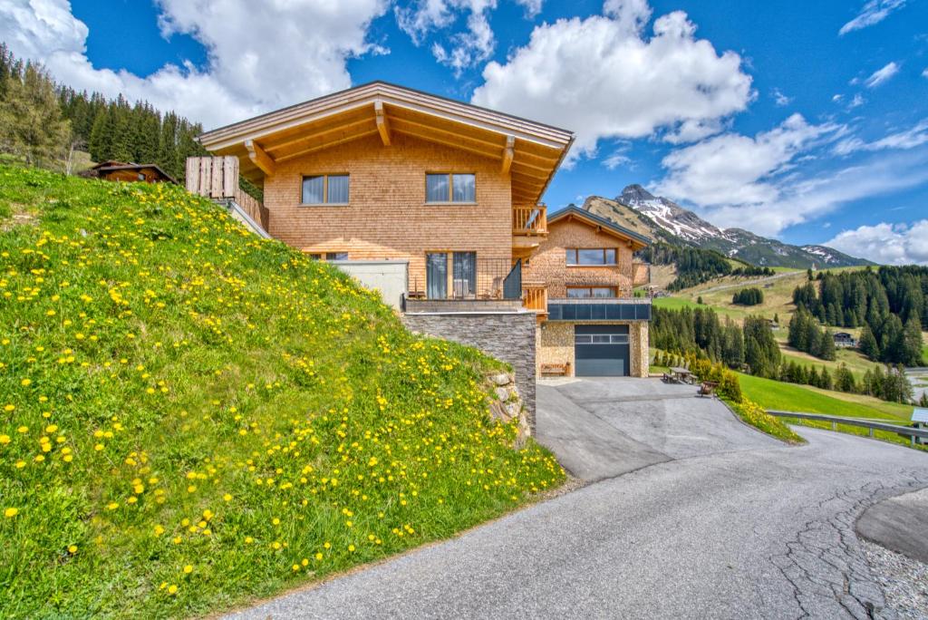 een huis op een heuvel met een weg bij Naturhaus am Arlberg in Warth am Arlberg