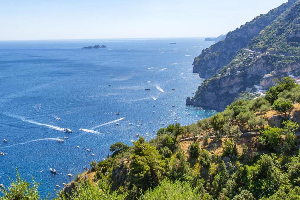 vista sulla costa amalfi con barche in acqua di Estate4home - Casa Sofia 330 steps a Positano