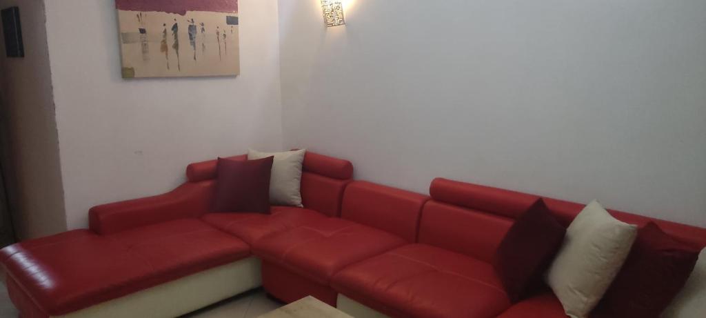 ein rotes Sofa im Wohnzimmer in der Unterkunft Appartement a louer pour les vacances in Tangier