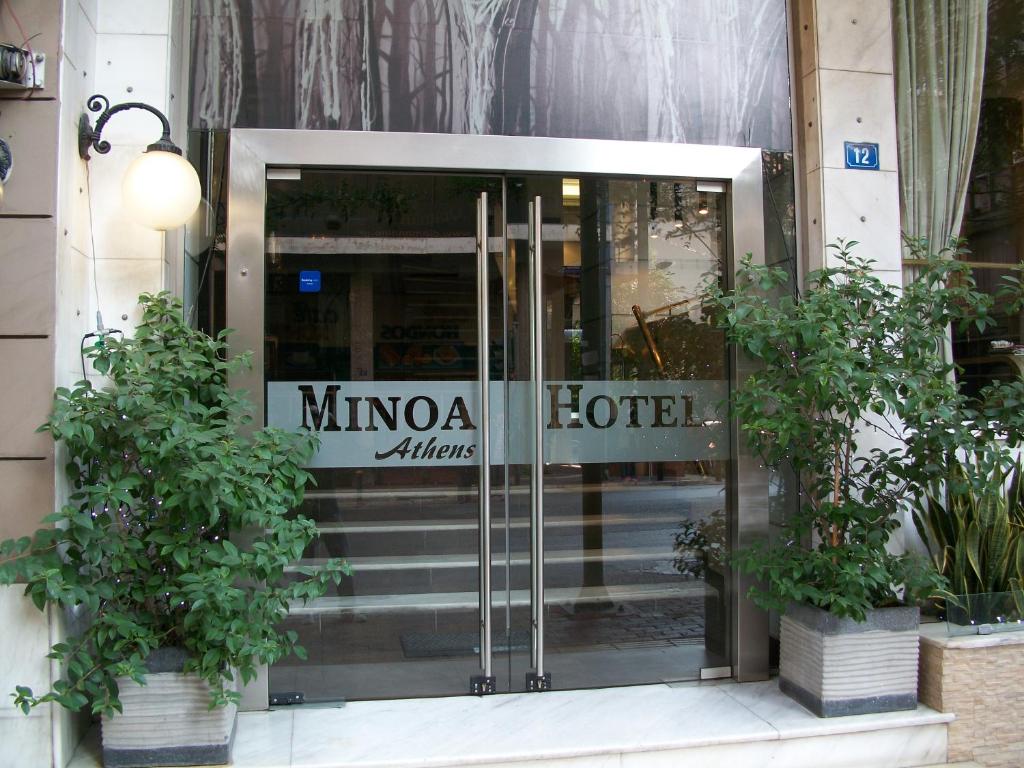 una entrada a un hotel con una puerta de cristal en Minoa Athens Hotel, en Atenas