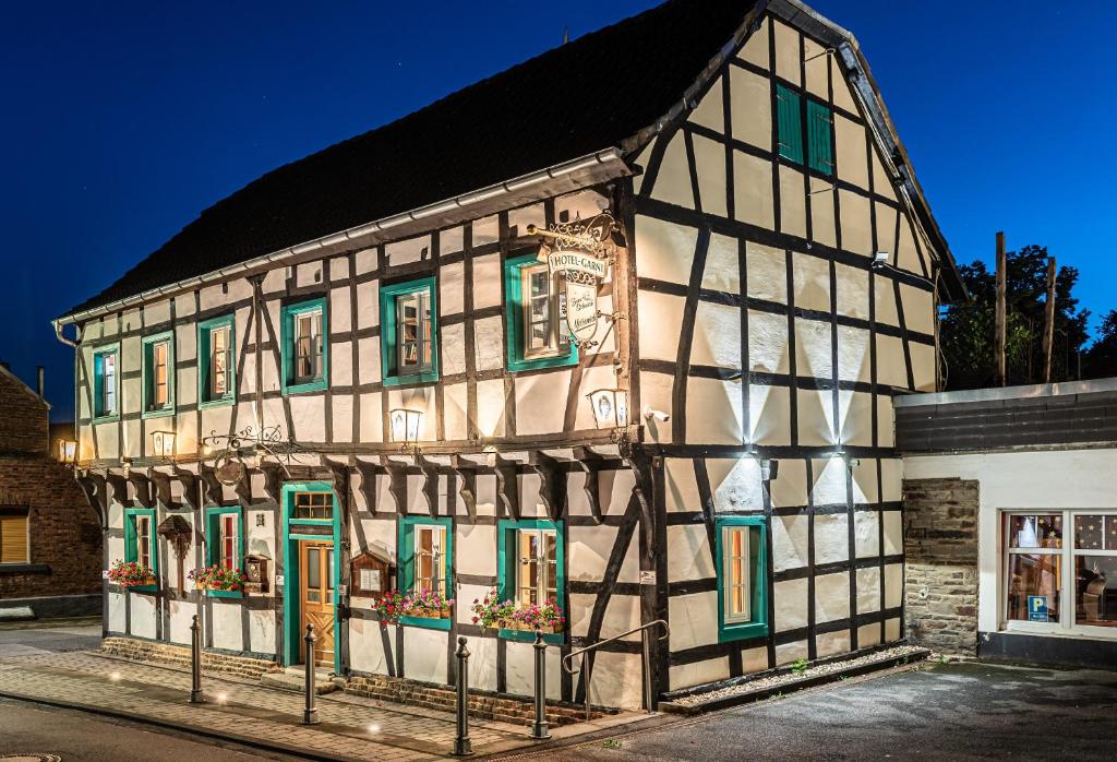 a half timbered building with green doors and windows at Land-Hotel Zum Schwan, Garni WEILERSWIST-METTERNICH in Weilerswist