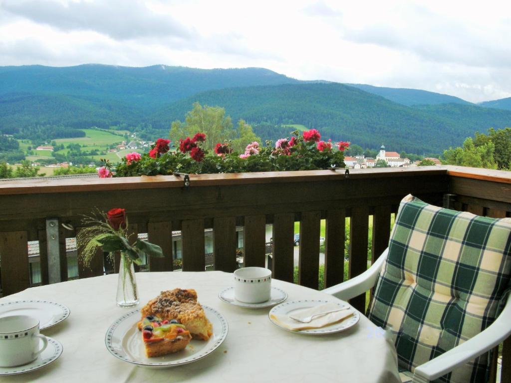 une table avec une assiette de nourriture sur un balcon dans l'établissement Appartementhaus Himmelreich, à Lam