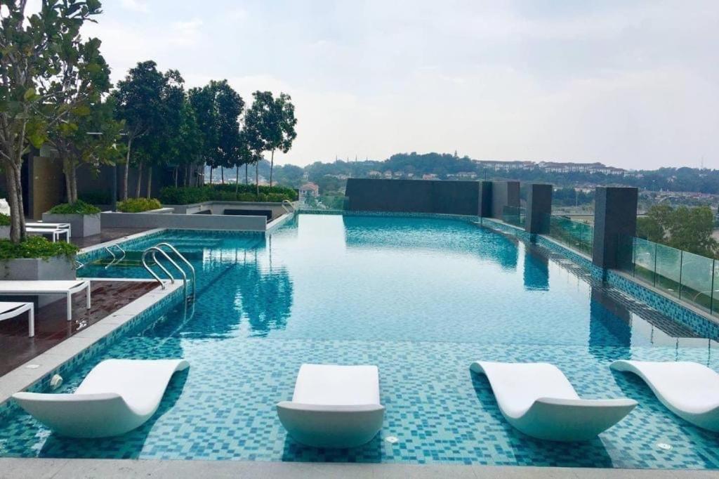 une piscine avec deux chaises et une piscine dans l'établissement Homestay Shah Alam, à Shah Alam