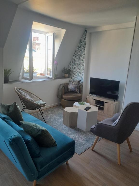 a living room with a couch and a tv at Le diepplex de Sébelle in Dieppe