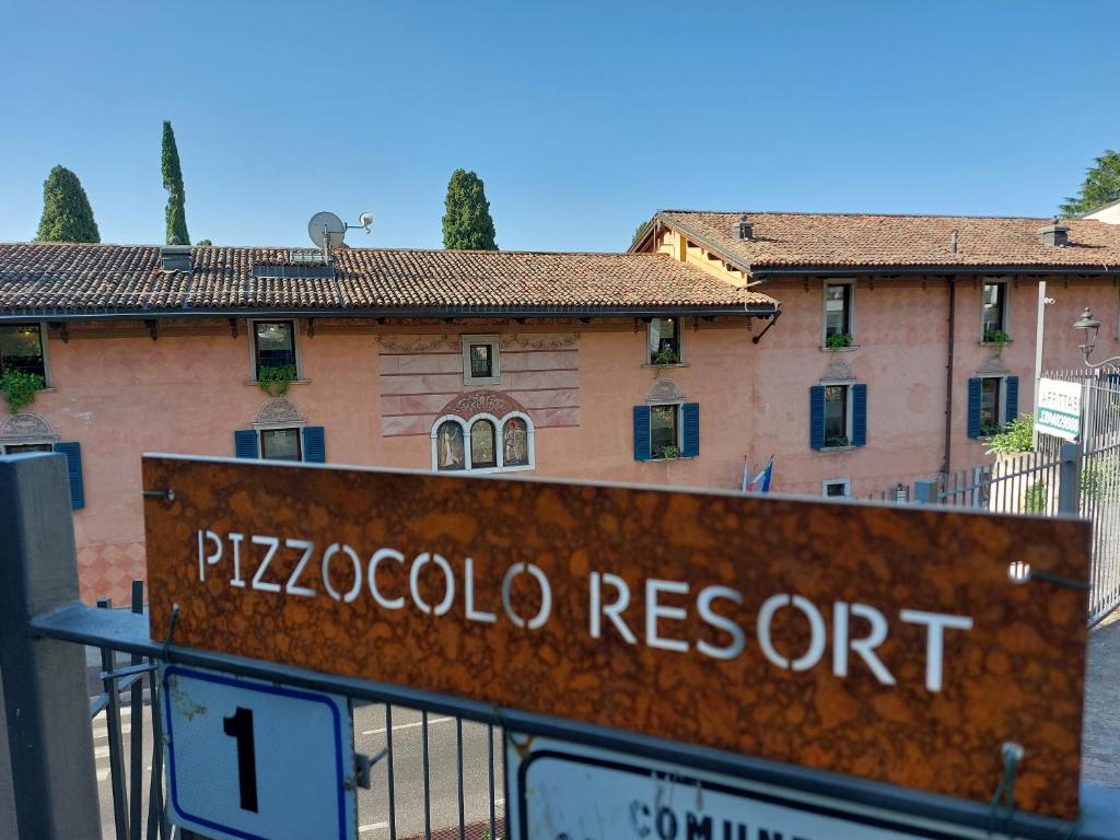 un cartel que lee el complejo de pizzaoco frente a un edificio en Pizzocolo resort fasano, en Gardone Riviera