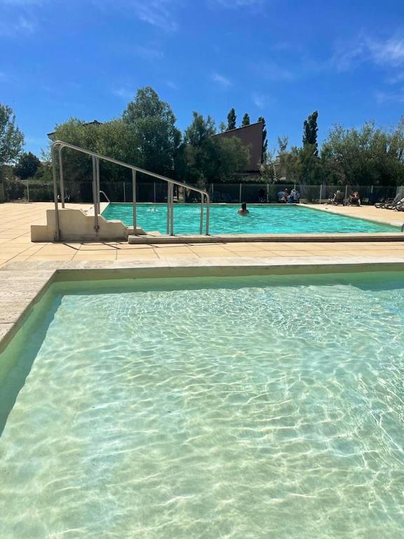 une grande piscine avec de l'eau bleue dans l'établissement Maison confortable Saint-Saturnin, à Saint-Saturnin-lès-Avignon