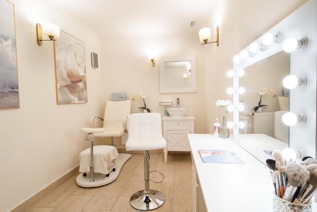 Bright beauty salon with makeup station, chair, and wall art. Elegant and inviting atmosphere.
