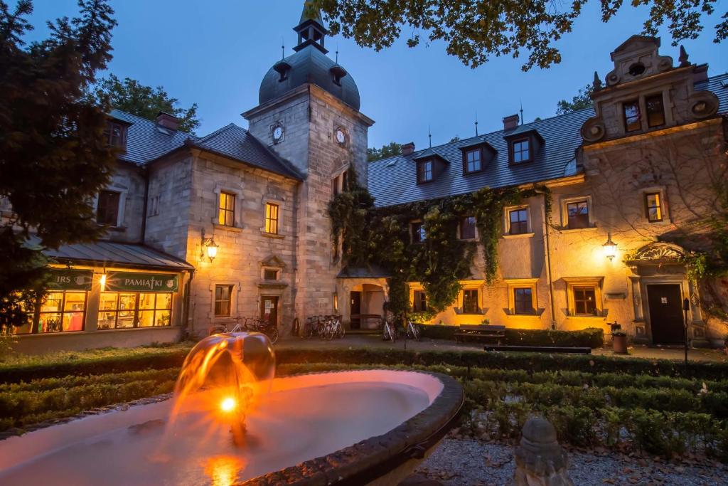 Historic building at dusk with a lit fountain and warm lighting.