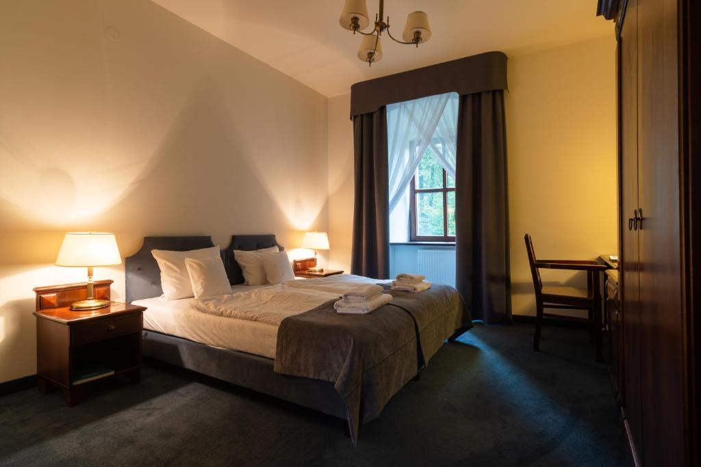 Warmly lit hotel room featuring a double bed and wooden furniture.