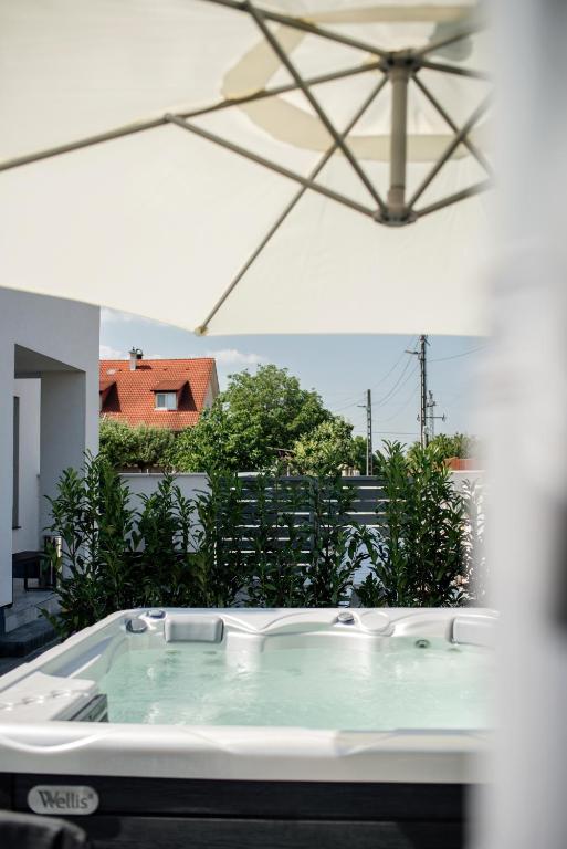 a jacuzzi tub on the balcony of a house at Style Inn Apartmanok in Veszprém
