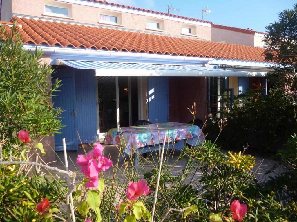 una casa azul con una pintura en la parte delantera en Les Bastides du Cap, en Le Barcarès