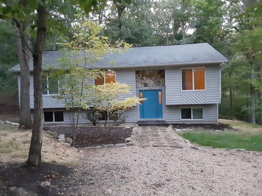 a small white house with a blue door at Mountain Gem in McGaheysville