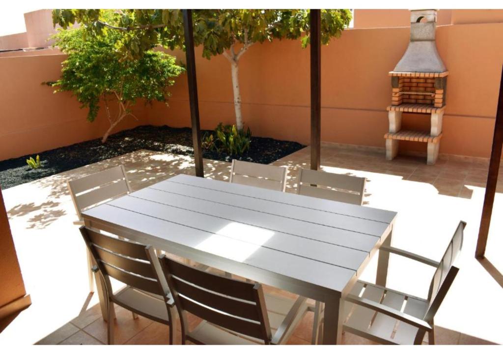 a white table and chairs on a patio at Anahi Homes Corralejo- Villa Drago 14 in La Oliva