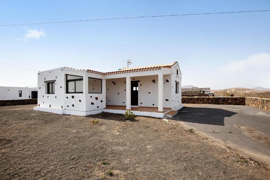 uma pequena casa branca no meio de um campo em Casa Cucu em Lajares