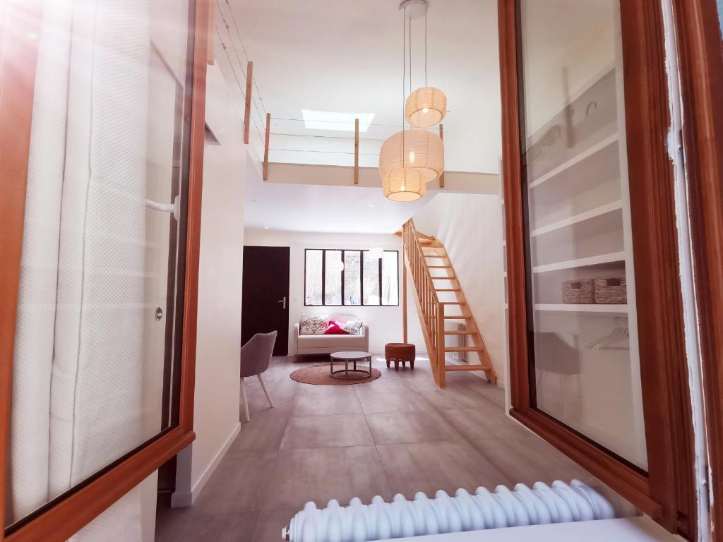 um corredor com uma escada e uma sala de estar em Le Saint Christophe - Mairie d'Aubervilliers ligne 12 em Aubervilliers