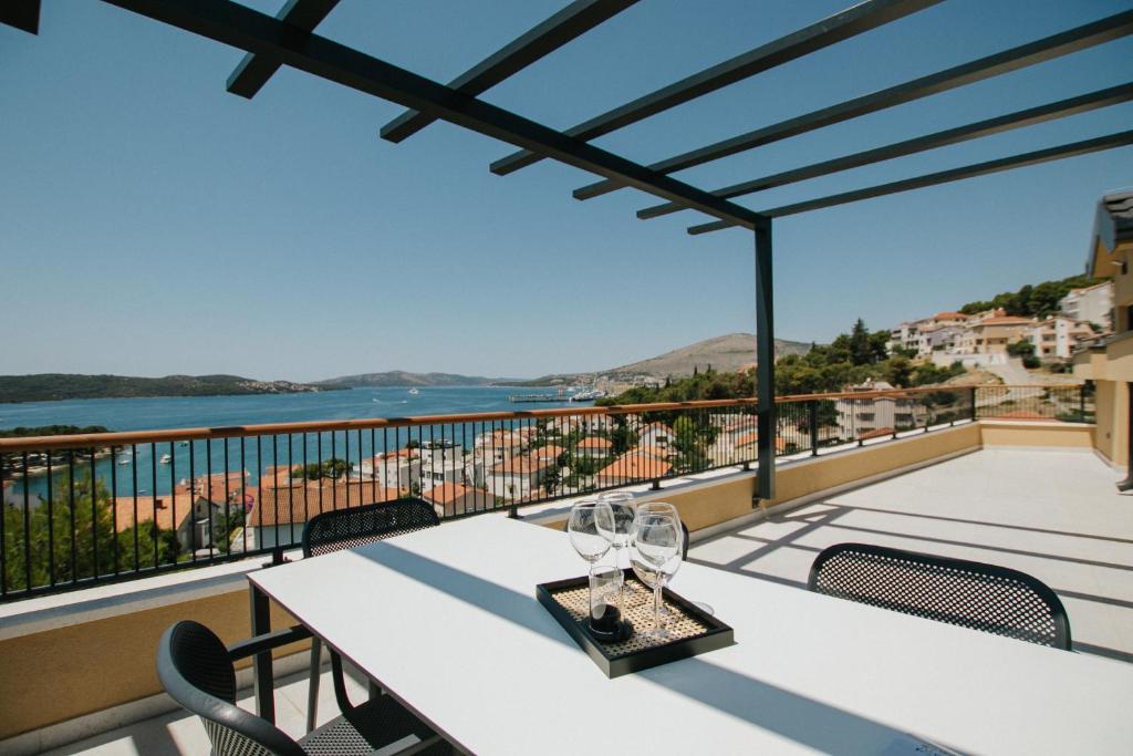 a table with wine glasses on a balcony at Oleander Urban Suites, high-speed internet, beach at 250, PET friendly in Trogir