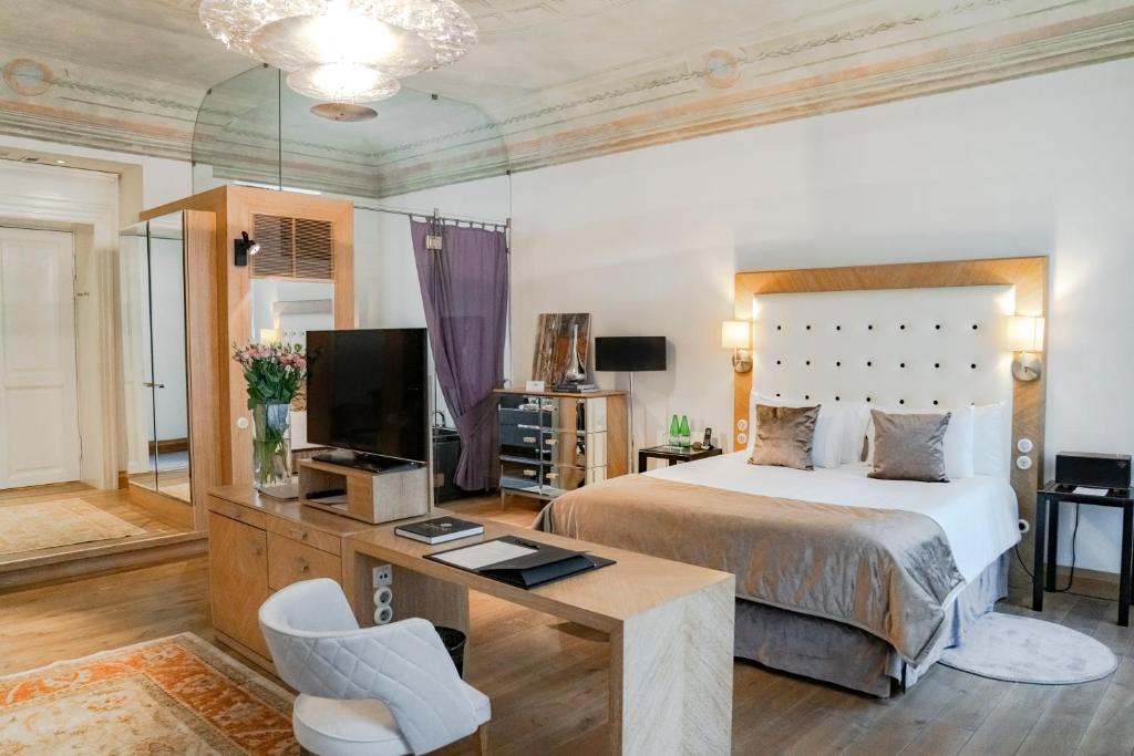 a bedroom with a bed and a desk and a tv at Dome Hotel in Rīga