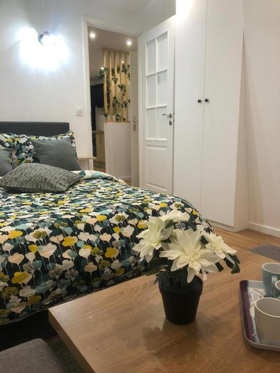 - une chambre avec un lit et une couverture fleurie dans l'établissement Appartement près de Paris & CDG& parc d'exposition, à Aulnay-sous-Bois