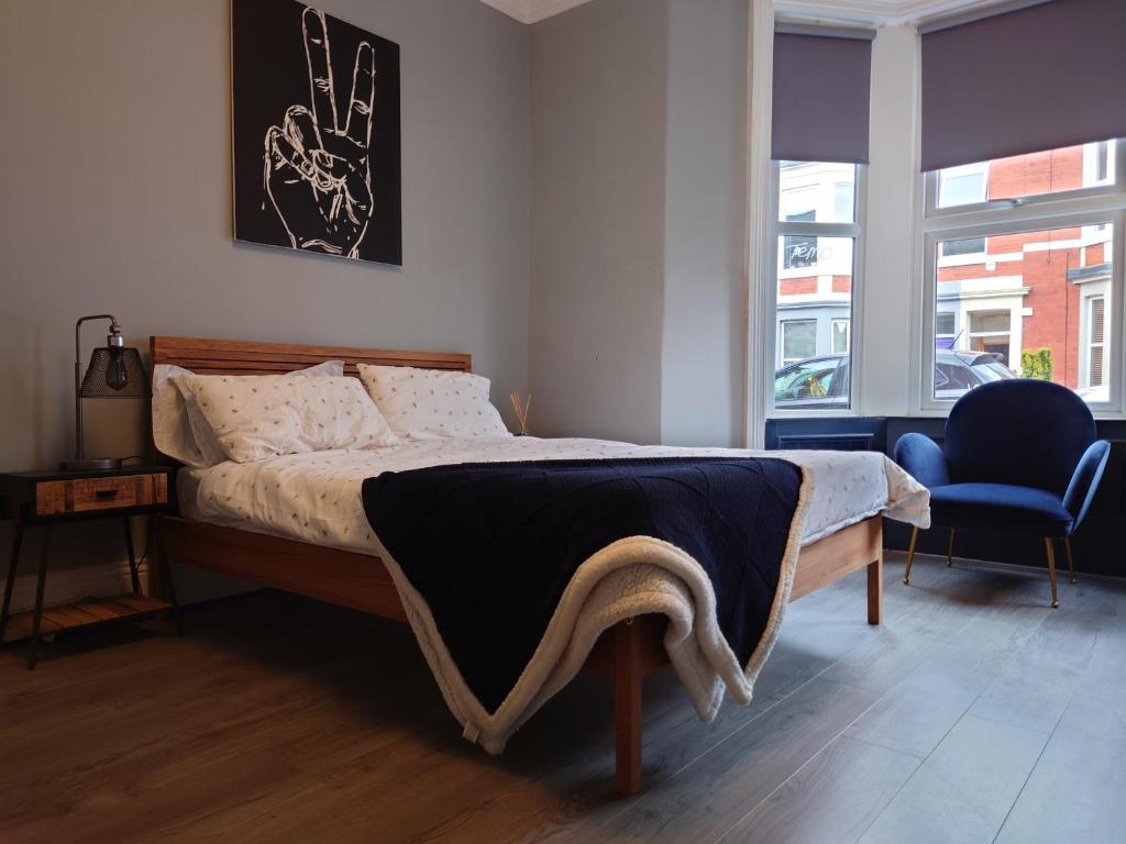 a bedroom with a bed and a blue chair at Entire Apartment Near Newcastle City Centre, West Jesmond. in Town Moor