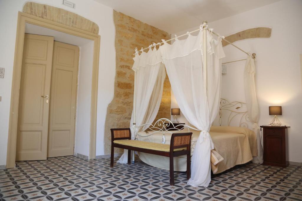 a bedroom with a bed and a table with a canopy at Charme in centro - Tourist rental in Agrigento