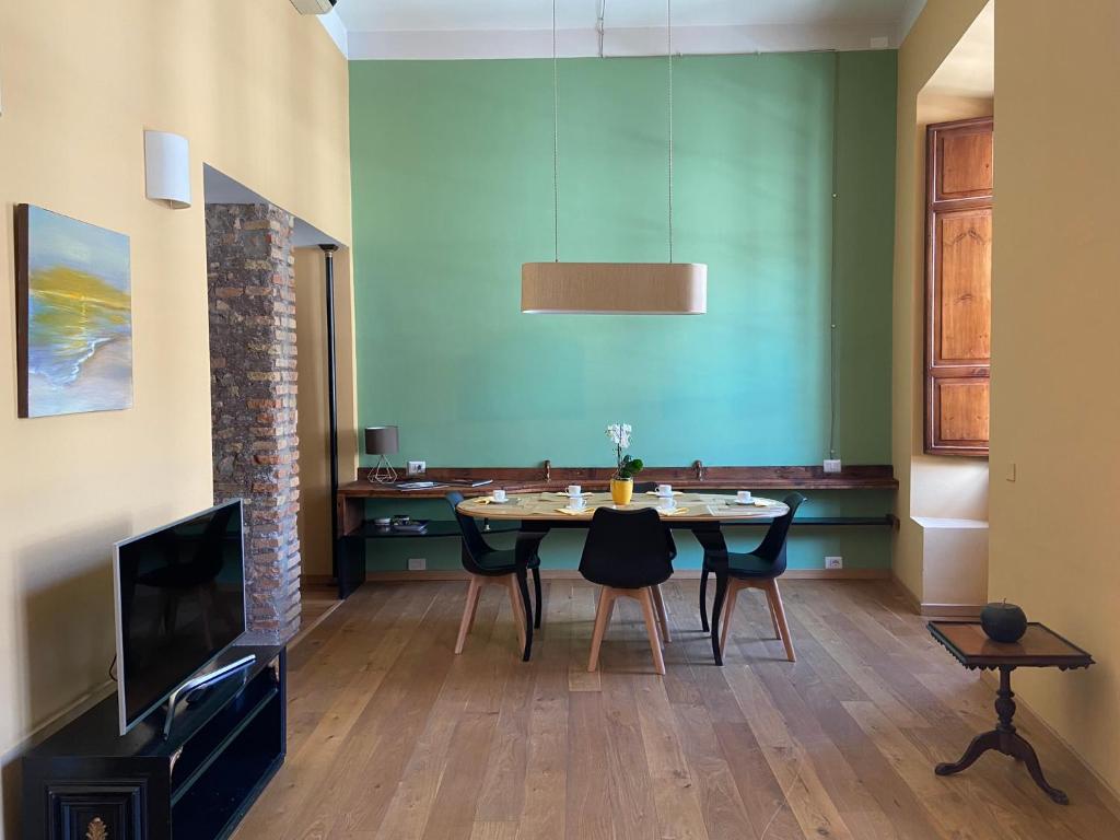 a dining room with a table and a tv at LA PIGNA in Rome
