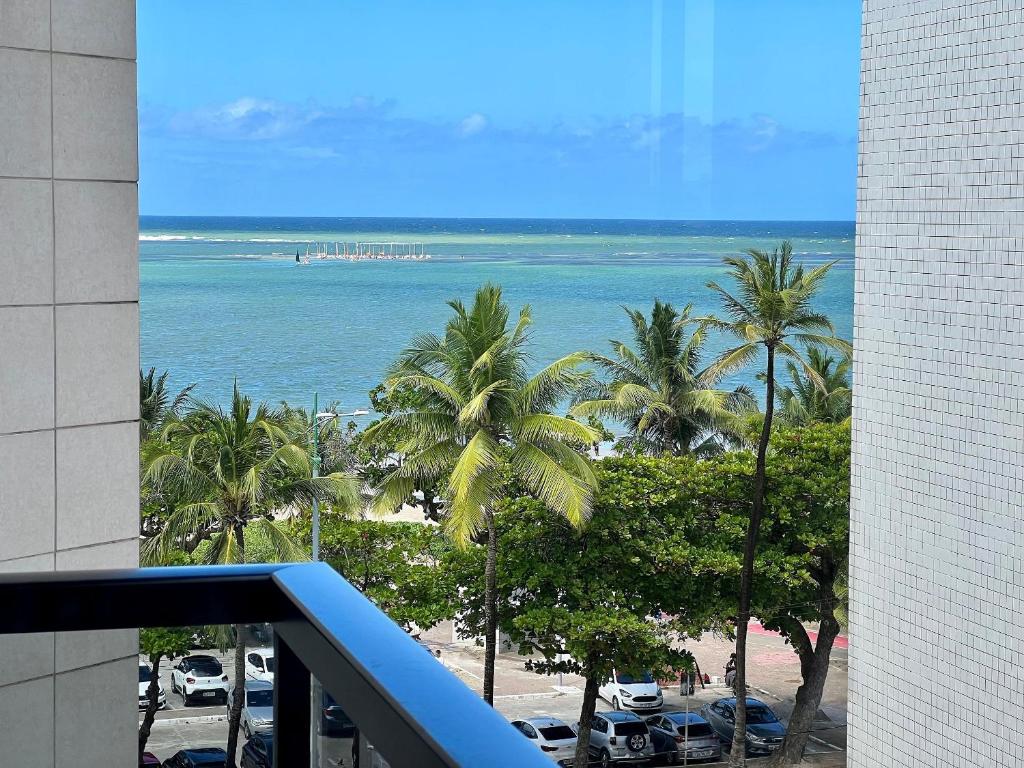 a view of a beach with palm trees and the ocean at Edf Casabela - Apartamento Beira Mar com 2 quartos sendo 1 suíte com vista para as piscinais naturais com ar condicionado em todos os quartos e na sala - 1 vaga de garagem in Maceió