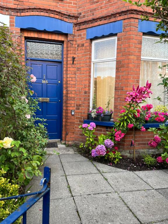 a blue door on a brick house with flowers at Brackenberry in Belfast