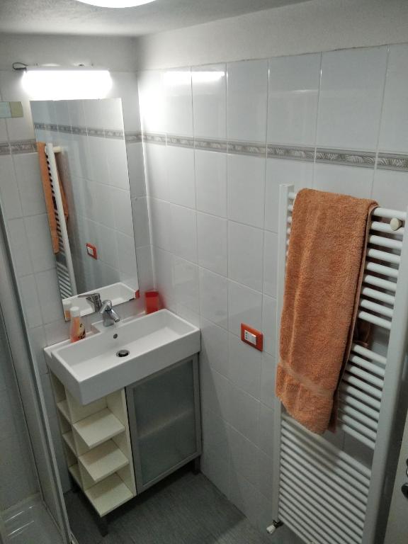 biała łazienka z umywalką i lustrem w obiekcie Costa dei trabocchi 2 w mieście San Vito Chietino